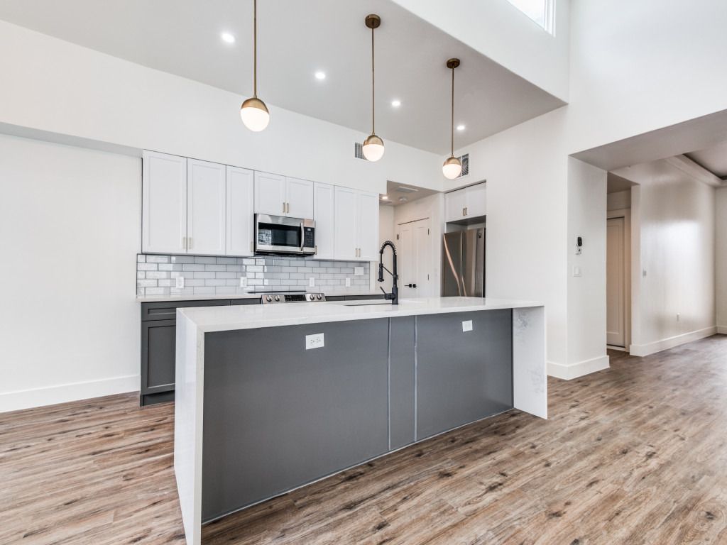 Great room flowing into a kitchen with dark island cabinetry